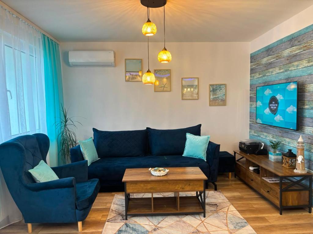 a living room with a blue couch and a table at Apartament Color4you Blue in Wschowa