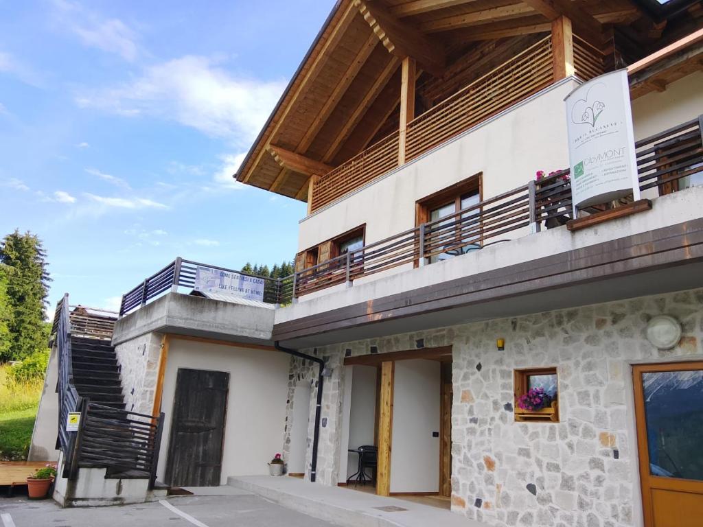 a building with a balcony on top of it at Affittacamere Sbulìa in Santo Stefano di Cadore
