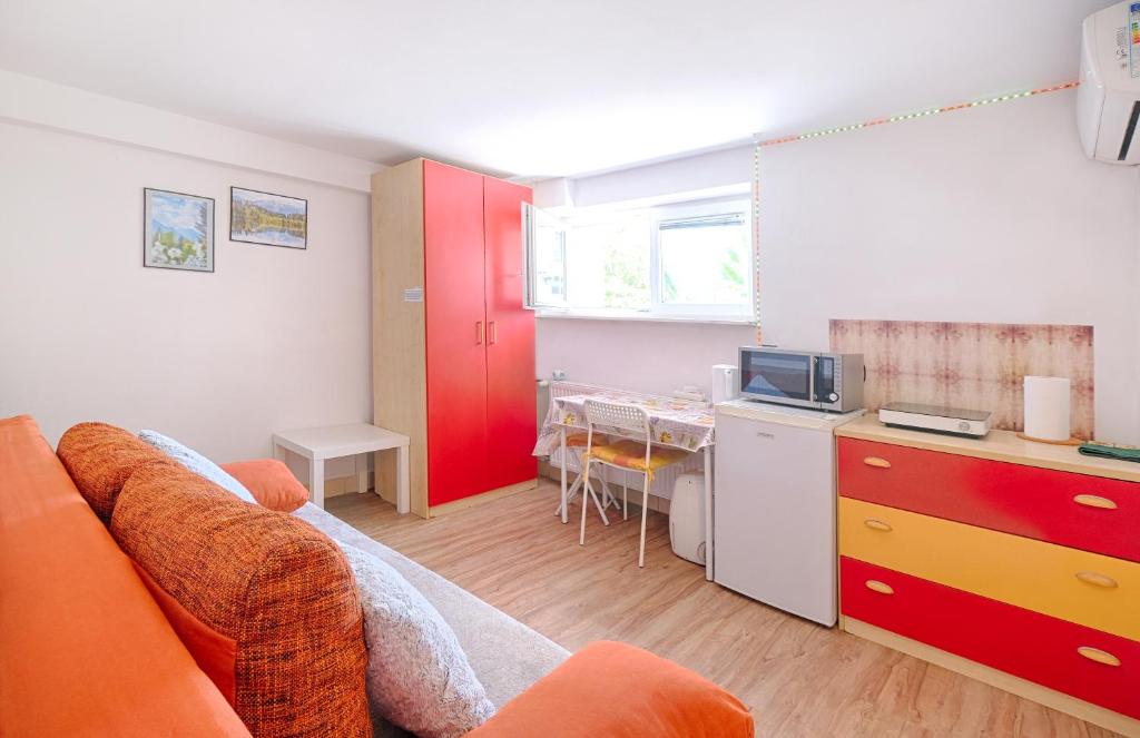 a living room with a couch and a kitchen with a table at Studio Southwest 1 with AirCon & FREE Parking in Ljubljana