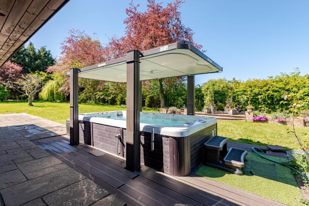 a hot tub with a canopy on a deck at The Limes Bungalow in Market Rasen