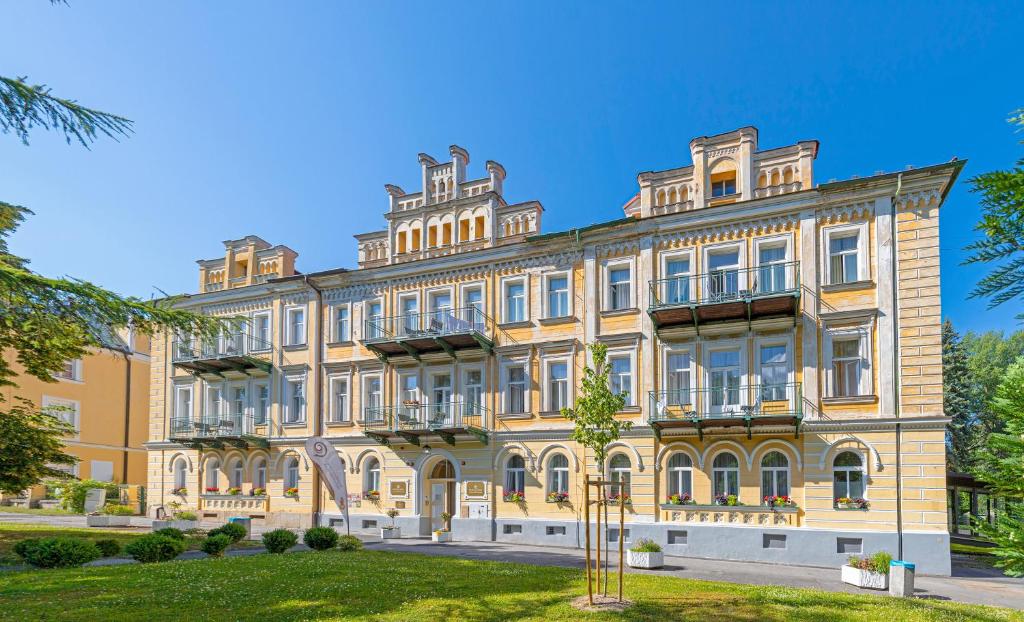 a large yellow building with many windows at Hotel Luisa in Františkovy Lázně