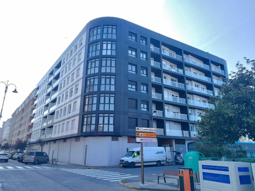 a large black building with a van parked in front of it at Apartamentos Illa Pancha in Ribadeo