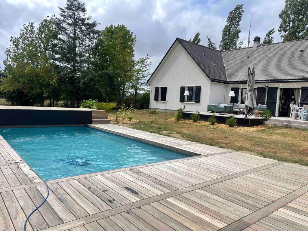 a swimming pool in front of a house at Villa de la Salmonière - Maison avec piscine et jardin clos in La Roche-Blanche