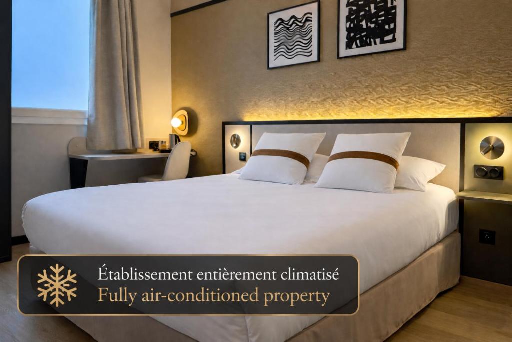 a hotel room with a large bed with a sign on it at Brit Hotel Saint-Méen-le-Grand en Brocéliande in Saint-Onen-la-Chapelle