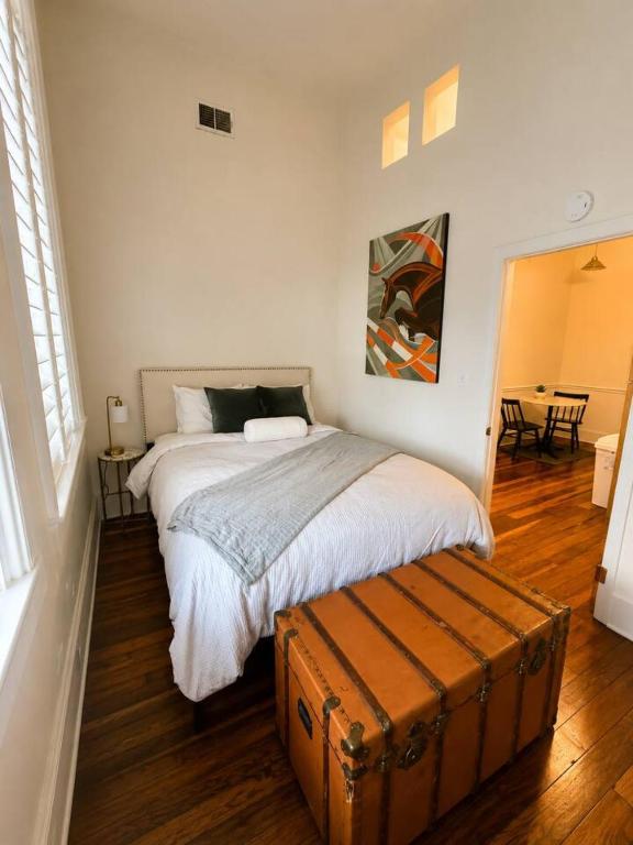 a bedroom with a bed with a suitcase next to it at Modern Main Street Charm in Georgetown