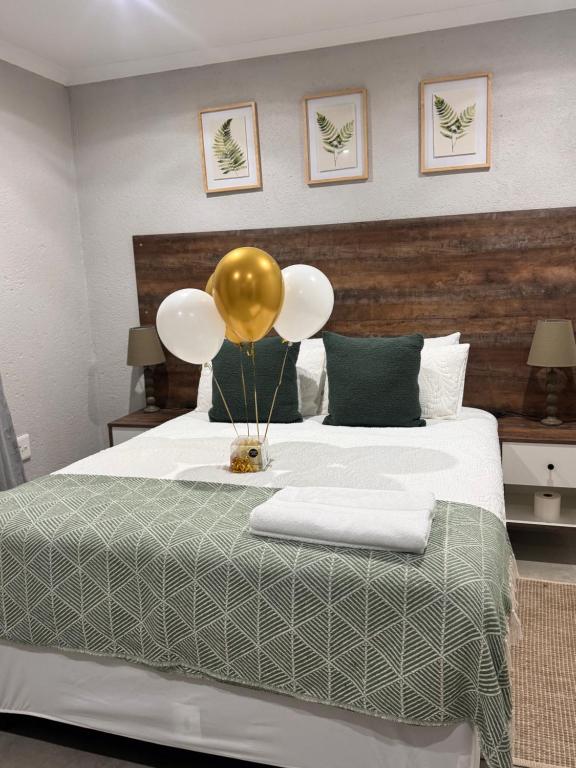 a bedroom with a bed with a balloon on it at Phumlani Village Lodge in White River