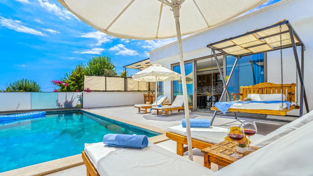 a villa with a swimming pool and a patio at Secluded Sea-View Family Escape-Villa Bella2 Sardunya in Üzümlü
