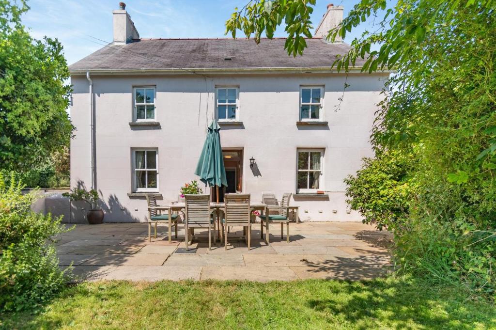 a white house with a table and chairs at 3 Bed in Castlemorris oc-94522 in Castlemartin