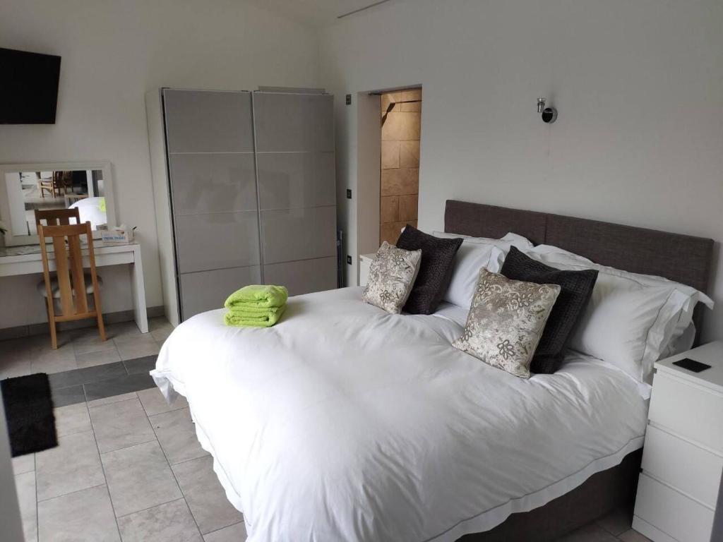 a bedroom with a bed with a green pillow on it at Egret Woody Park in Willand