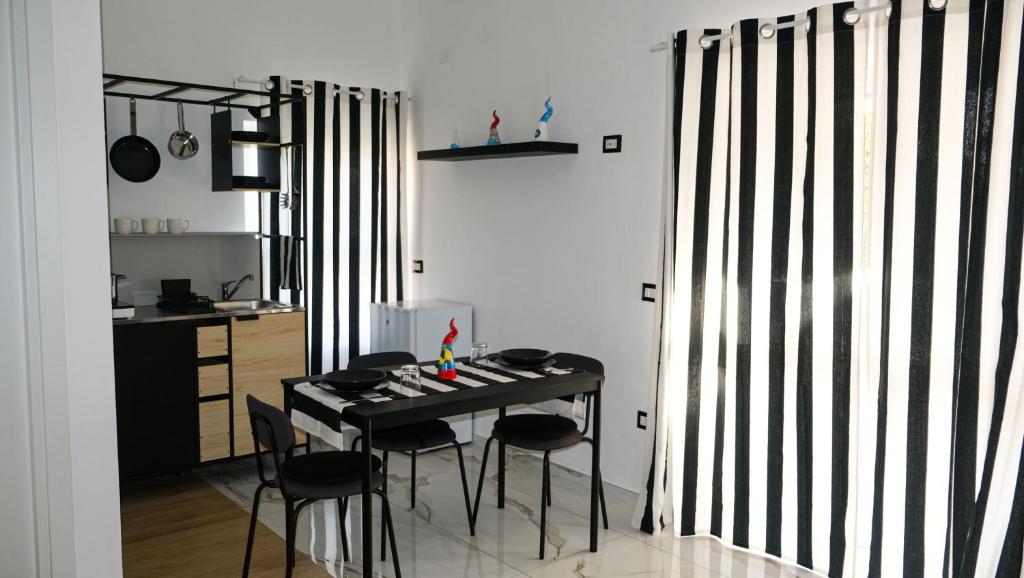 a dining room with a table and some chairs at Aura Apartments in Pompei
