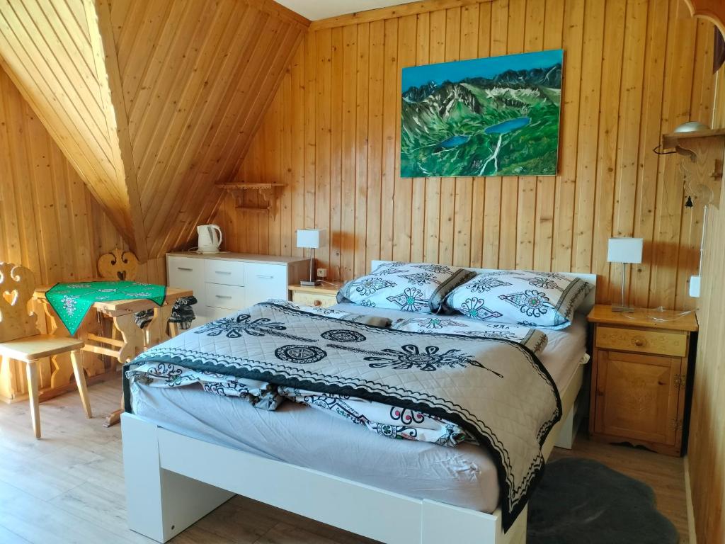 a bedroom with a bed and a wooden wall at U Stenia in Murzasichle