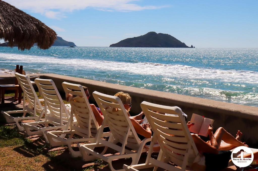a child sitting in lawn chairs on the beach at Villas El Rancho Green Resort in Mazatlán