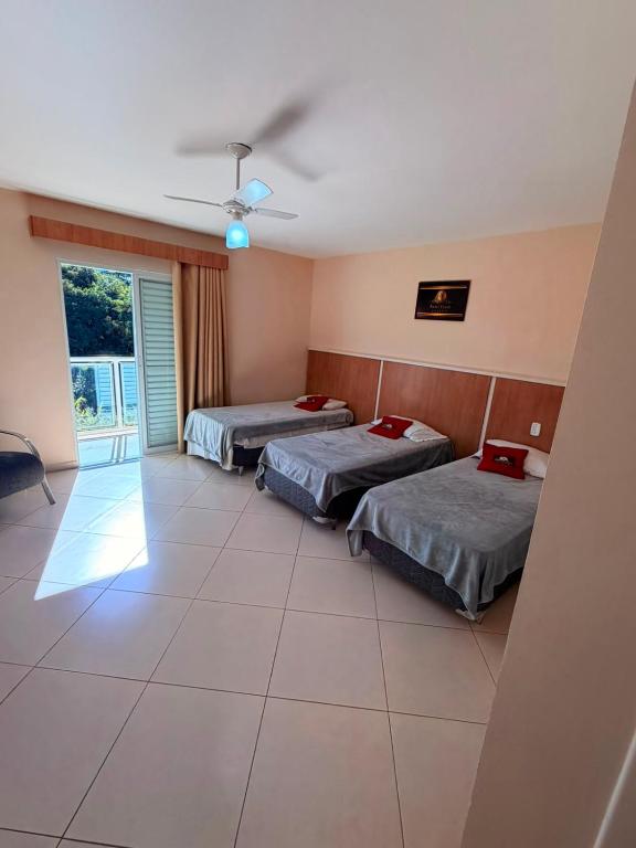 a room with two beds and a window at Hotel Canaã Express in Jarinu