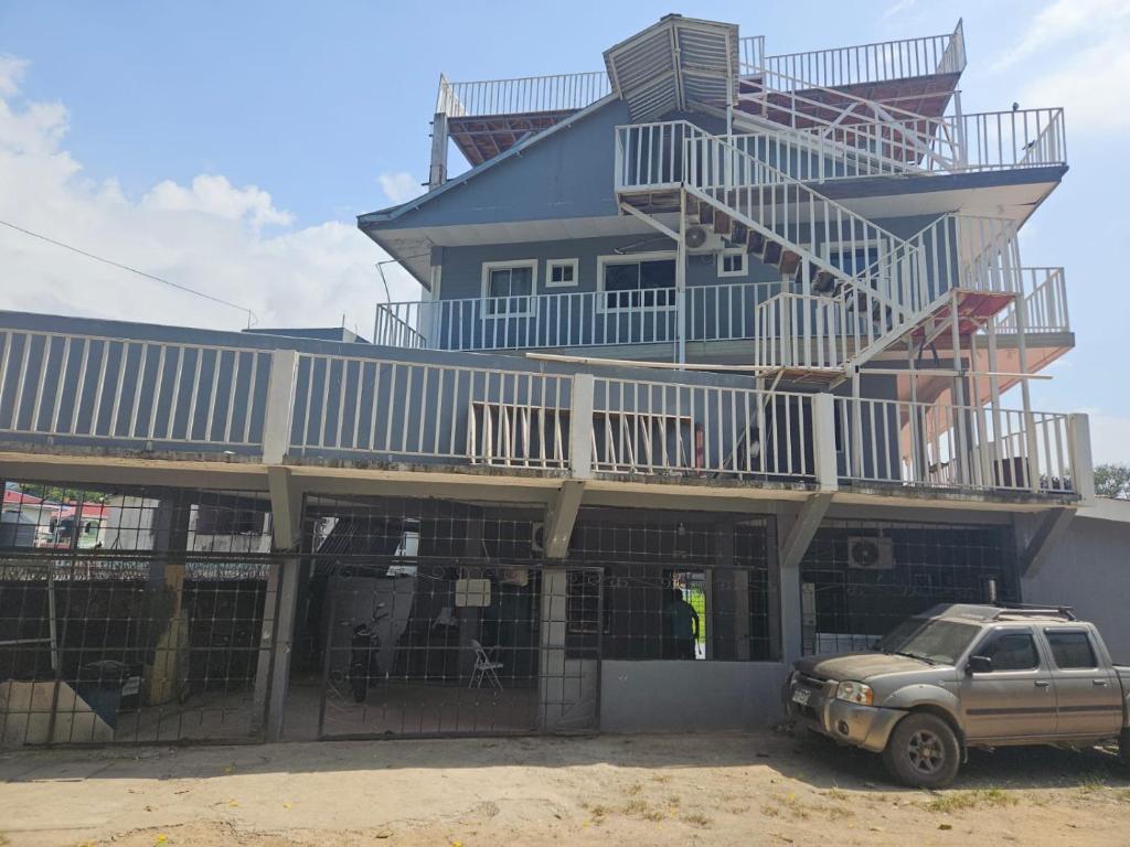 a house with a car parked in front of it at Hotel Atlántida in La Ceiba