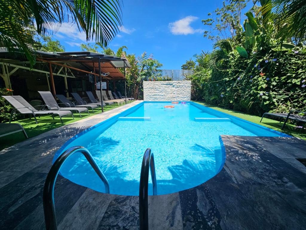 a swimming pool with chairs in a resort at Ballena Rey Hotel in Uvita