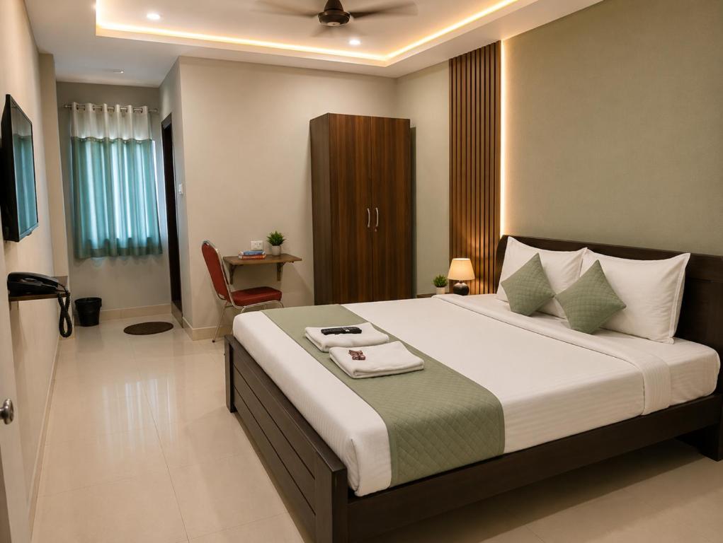 a bedroom with a large bed and a desk at Hotel Rise Grand Kukatpally Near Hitex Exhibition Center & Nexus Mall, Yashoda Hospital in Hyderabad