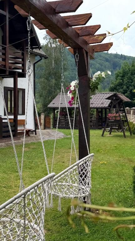 a swing in a yard with a house at Olko House in Yaremche