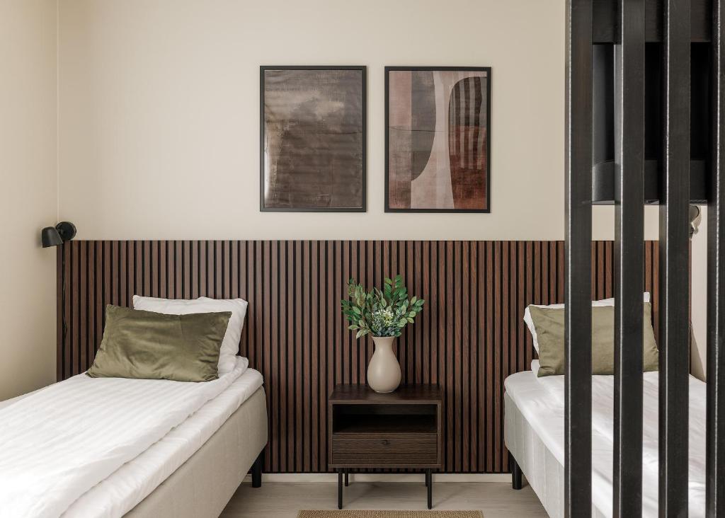 a bedroom with two beds and a vase on a table at Calm Design Studio with Balcony & Parking in Pori