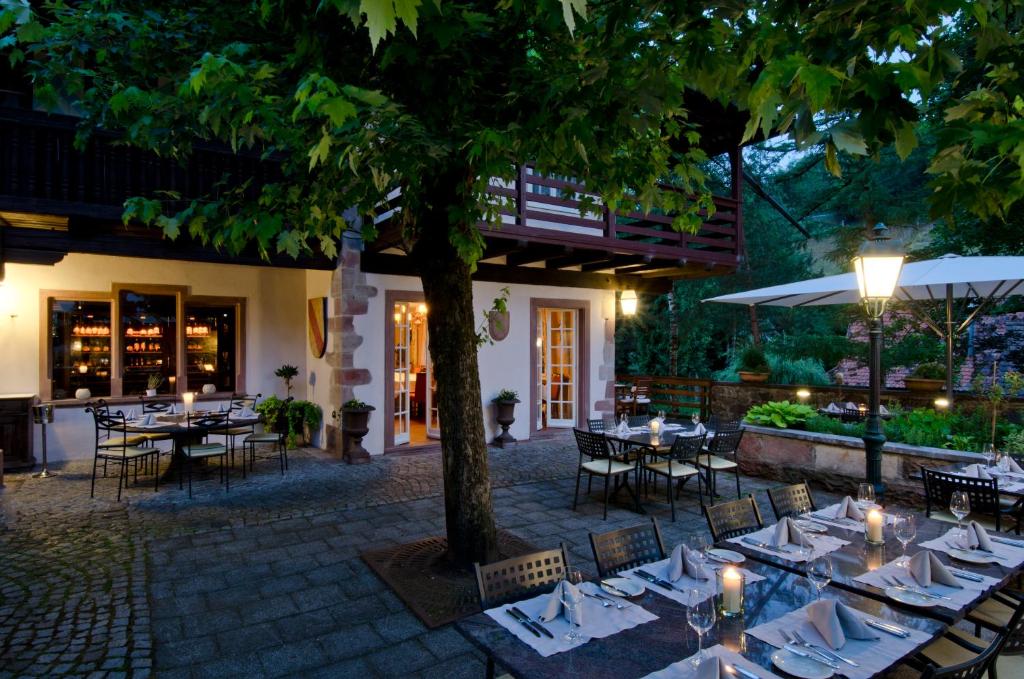 ein Restaurant mit Tischen, Stühlen und einem Baum in der Unterkunft Landgasthof zur Sonne in Wehr