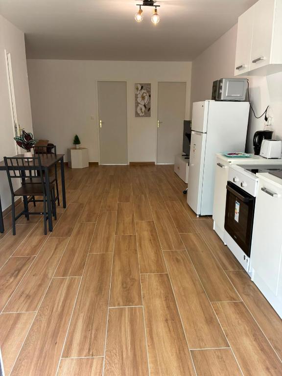 an empty kitchen and living room with a wooden floor at NovaStay in Breuillet