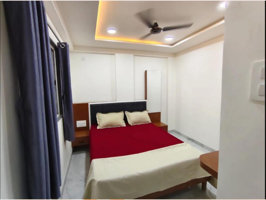 a bed in a room with a ceiling fan at ishwari heights lodging in Pandharpur