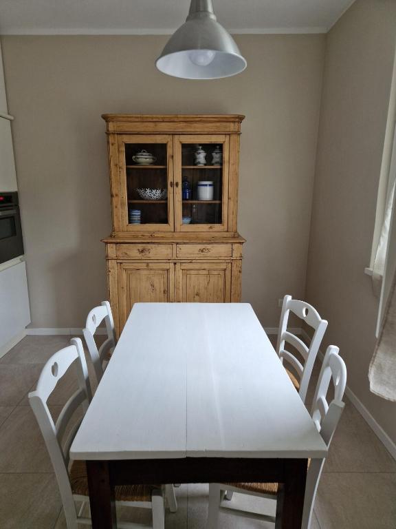 a dining room with a white table and white chairs at La Casina di Titty in Stia