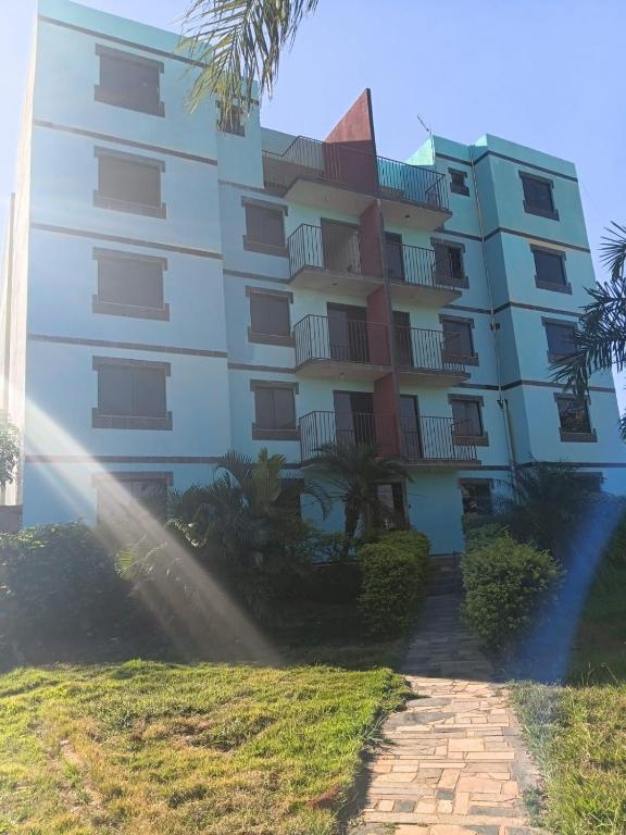 a tall building with a palm tree in front of it at Hotel X in Valparaíso de Goiás
