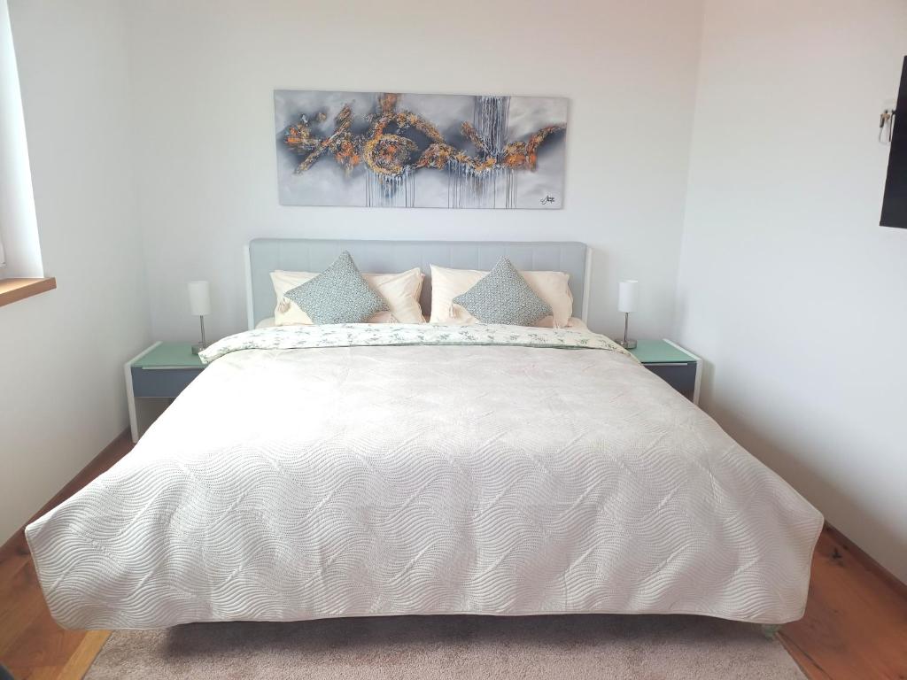 a bedroom with a large white bed with pillows at Exclusive Apartment mit Alpenpanorama in Peiting