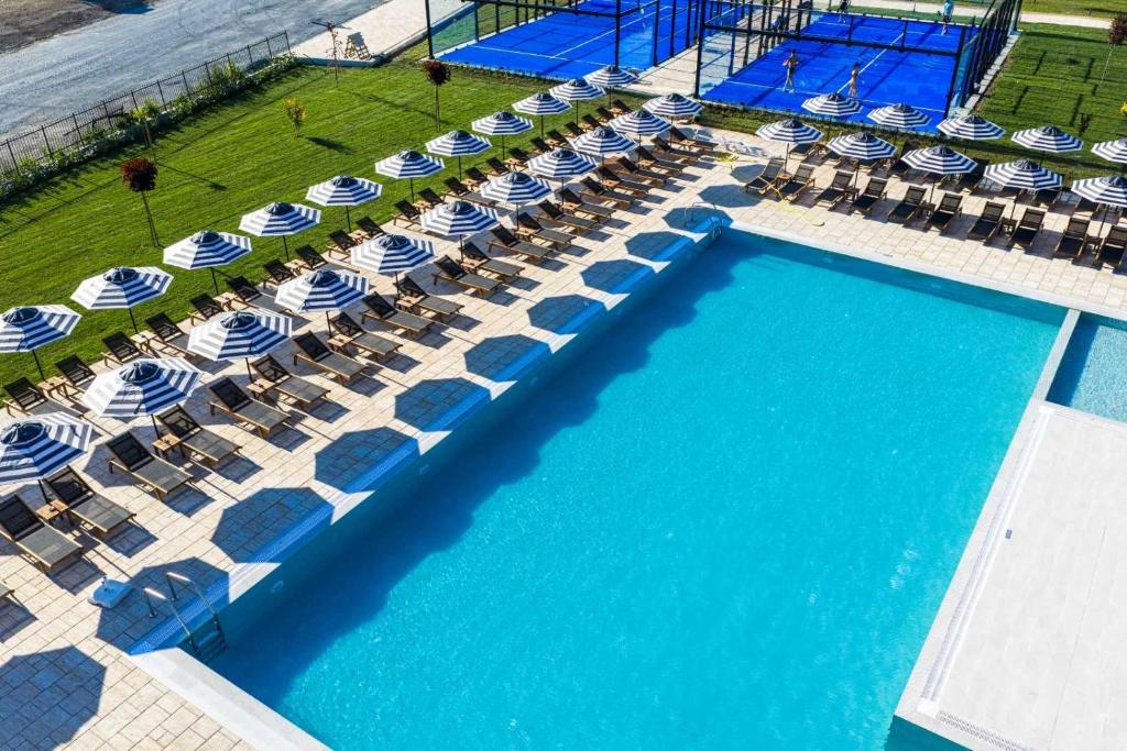 an overhead view of a swimming pool with umbrellas and chairs at Комплекс Шампион in Kazanlŭk