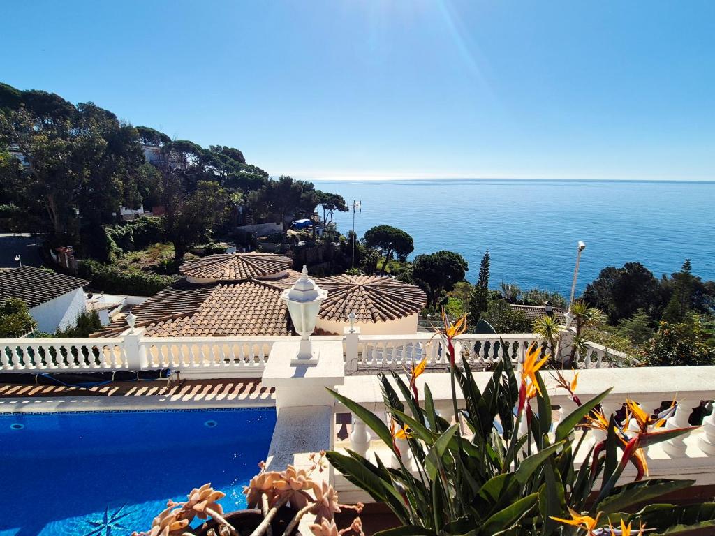 a house with a swimming pool next to the ocean at La Marina in Lloret de Mar