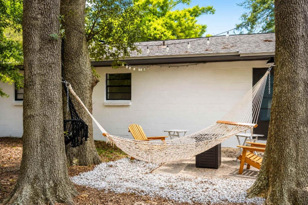 a hammock hanging between two trees in a yard at The PanAm fire pit bbq kid & dog friendly in Pensacola