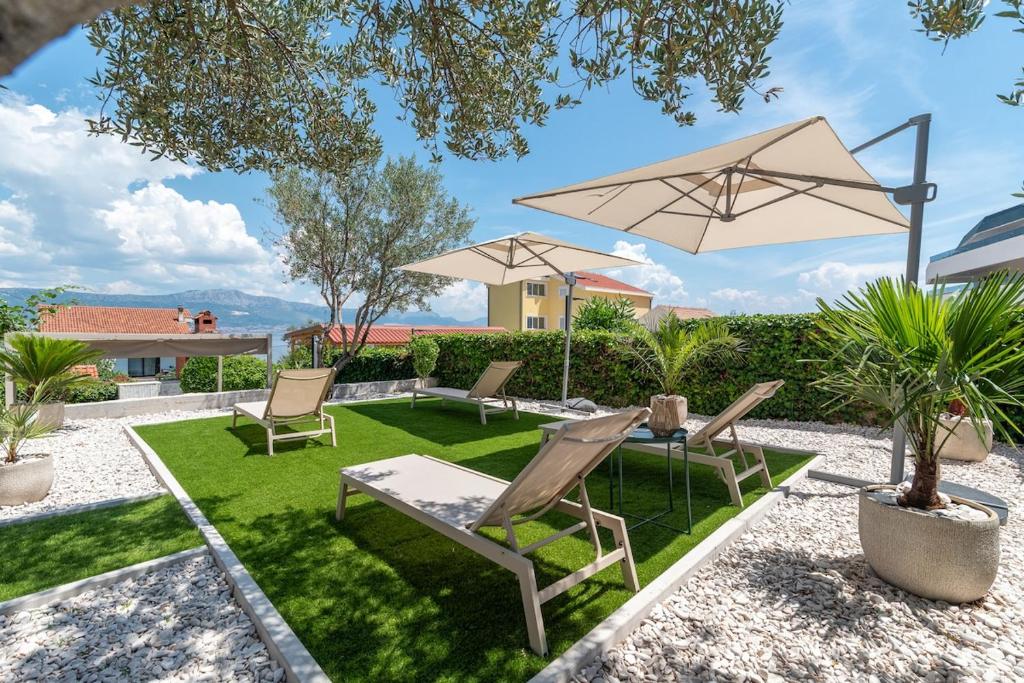 a patio with chairs and a table and umbrella at Guest house Bella in Slatine