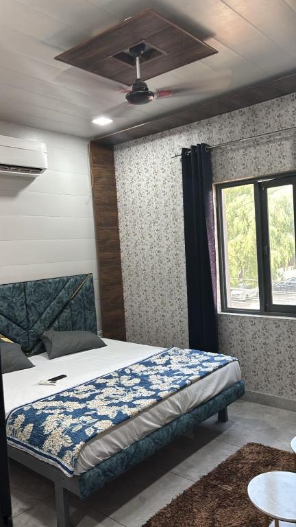 a bedroom with a bed and a ceiling fan at Hotel Dhamija divine inn in Sirsa