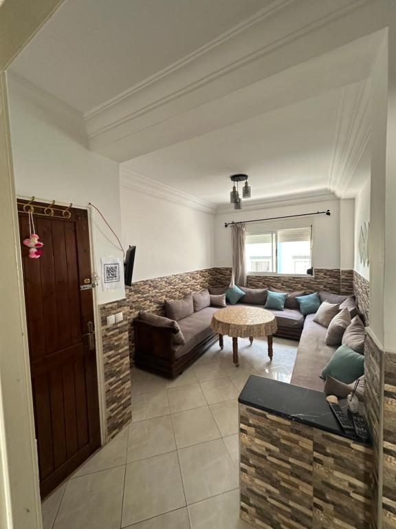 a living room with a couch and a table at Appart Firdaous in Martil