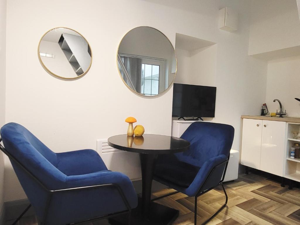 a room with two blue chairs and a table and a mirror at Historic Loft in Cork in Cork