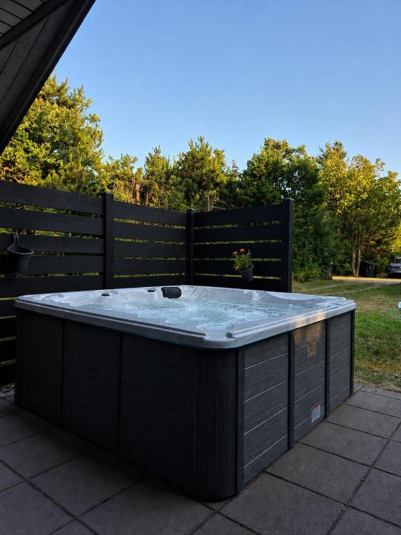 a black hot tub sitting on a patio at Sommerhus ved Vesterhavet in Ulfborg