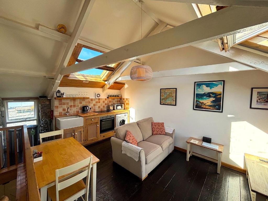 a living room with a couch and a table at Abbey Place Net Loft in Mousehole