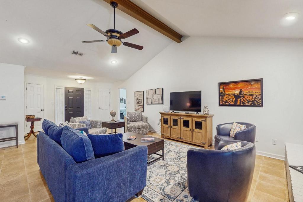 a living room with blue couches and a flat screen tv at <1 Block to Trails! Conway Biker & Hikers Haven in Conway