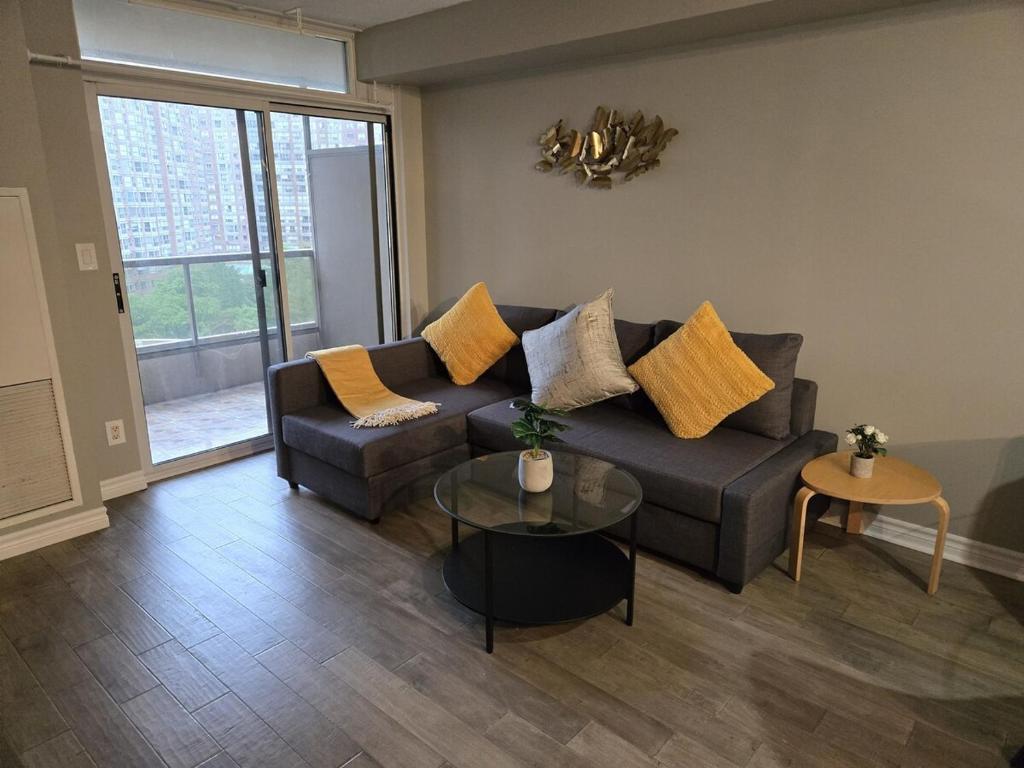 a living room with a couch and a table at Designer Apartment in Prime Location in Mississauga
