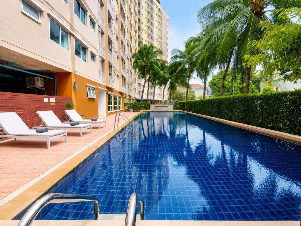 a swimming pool with lounge chairs next to a building at Apartment Phuket Old Town Fast Wifi Netflix Pool Gym Cityview in Phuket