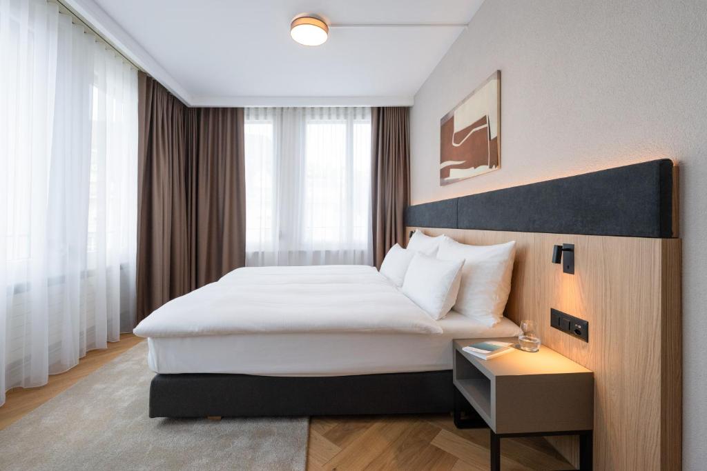 a hotel room with a bed and a table at Tailormade Hotel METROPOL St Gallen in St. Gallen