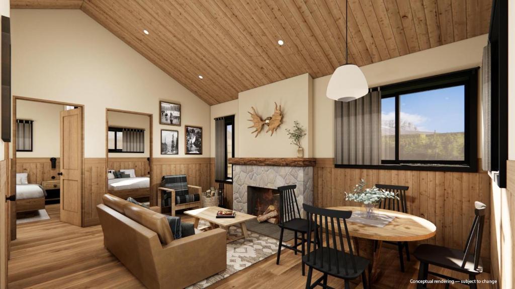 a living room with a couch a table and a fireplace at Tekarra Lodge in Jasper