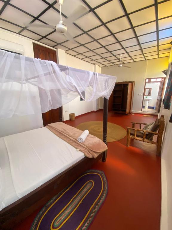 a bedroom with a bed with a mosquito net at Tonys homestay in Zanzibar City