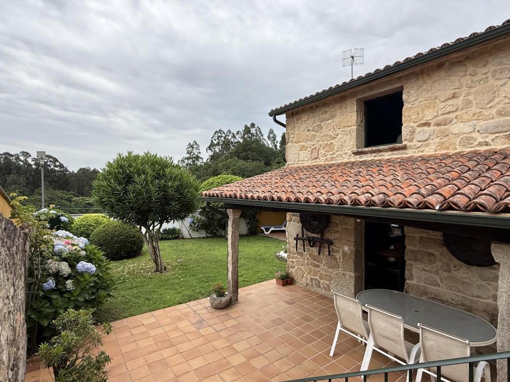 a patio with two chairs and a house at BLEU MAISON-PAZO 1 CL in Campo Lameiro