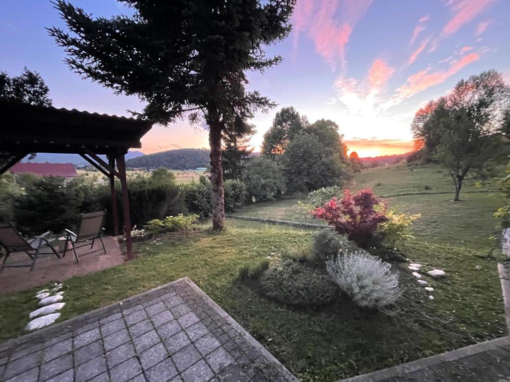 a garden with a view of the sunset at Apartma Loško in Cerknica