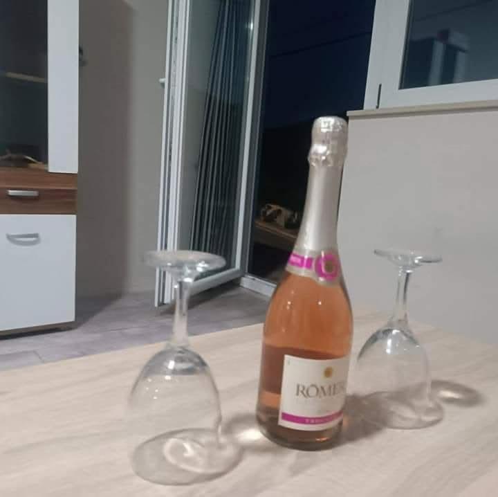 two wine glasses and a bottle on a table at Kravica Oasis in Ljubuški