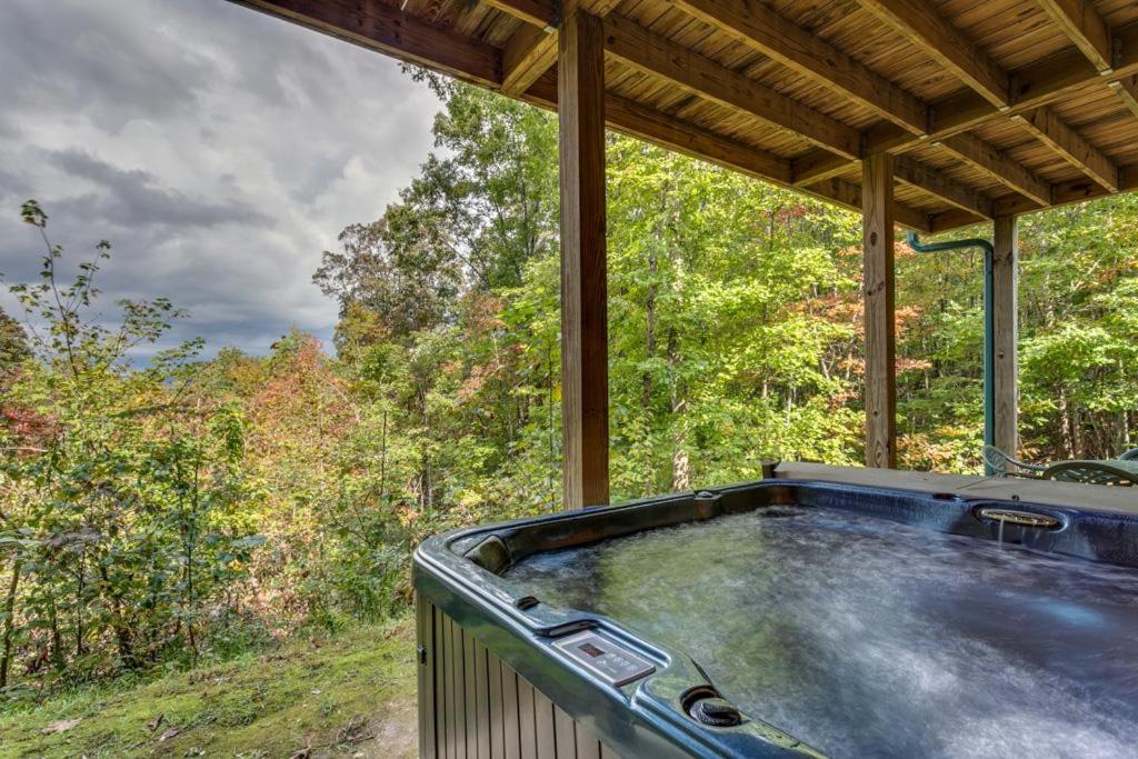a hot tub sitting on the back of a house at Treetops Hot Tub Fire Pit Pool Table in Copperhill