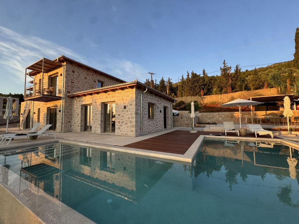 a house with a swimming pool next to a building at Limestone House in Athani