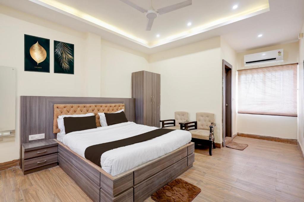 a bedroom with a large bed and a chair at Hotel O Rajdhani Heritage in Nāmkom