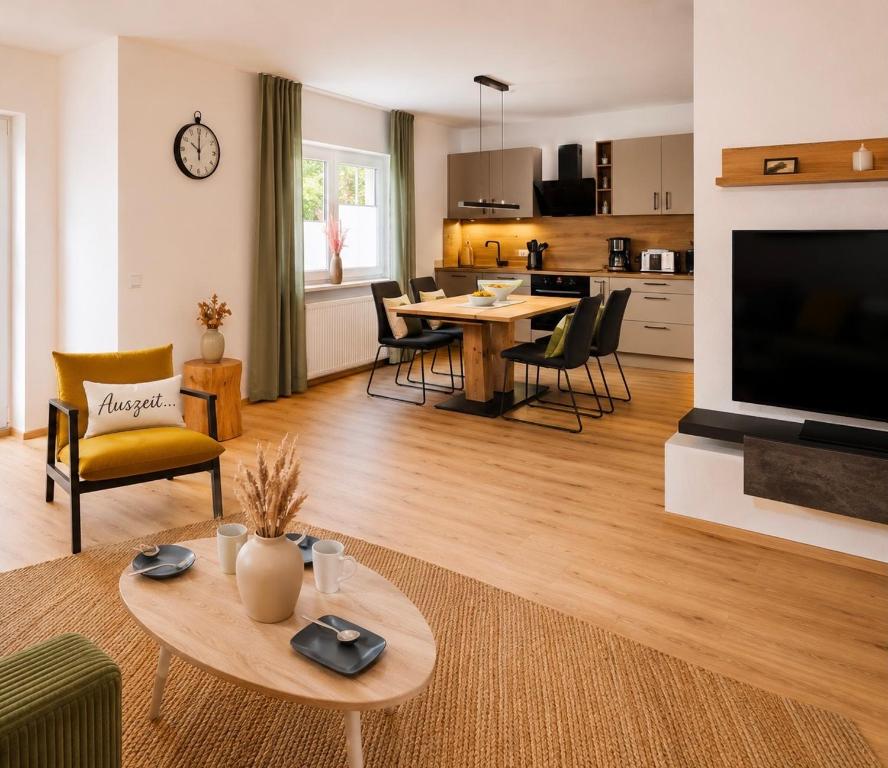 a living room with a table and chairs and a kitchen at Zwei Apartments - ein Haus - Alles fußläufig - Altstadt, Wanderwege, Freibad und Restaurants in unmittelbarer Nähe in Schmallenberg